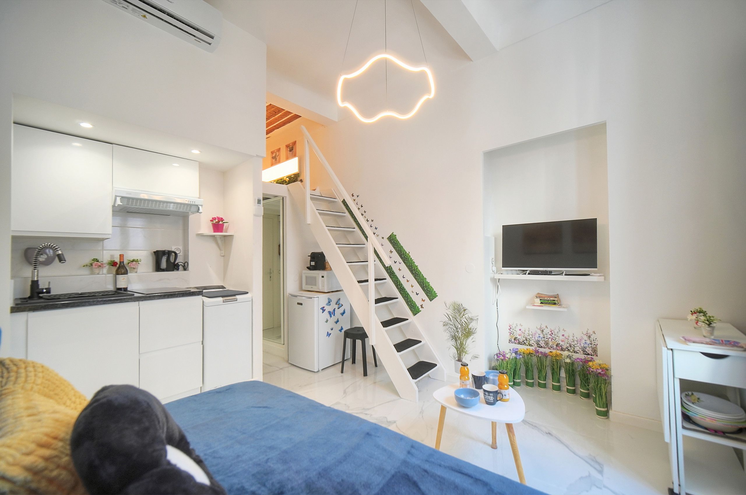 A modern kitchen with white cabinets, a built-in microwave, and a coffee machine.