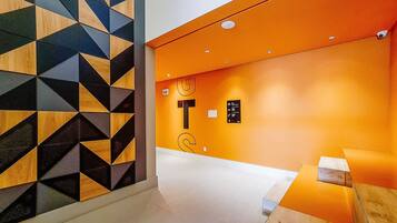 Un interior moderno con paredes de diseño geométrico, una pared de acento naranja brillante y un estilo minimalista y limpio.