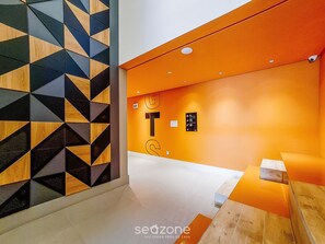 A modern interior with geometric patterned walls, a bright orange accent wall, and a clean, minimalist design. - Stay in a Building With a Pool, Gym, and Leisure - SSL (Florianópolis)