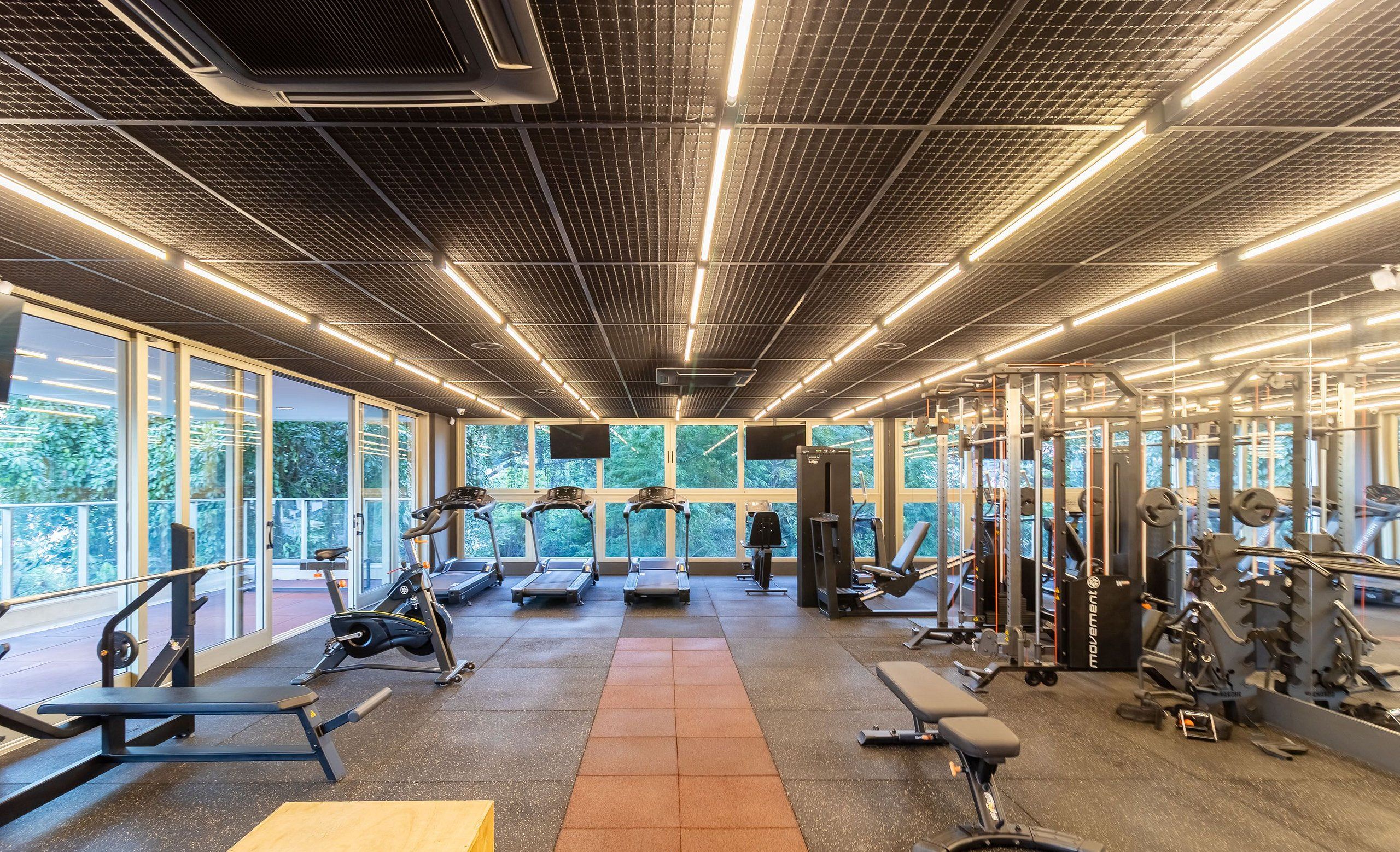 A gym with treadmills, weight machines, and benches.