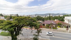 Une vue de rue avec un passage piéton, une voiture blanche et des bâtiments en arrière-plan.