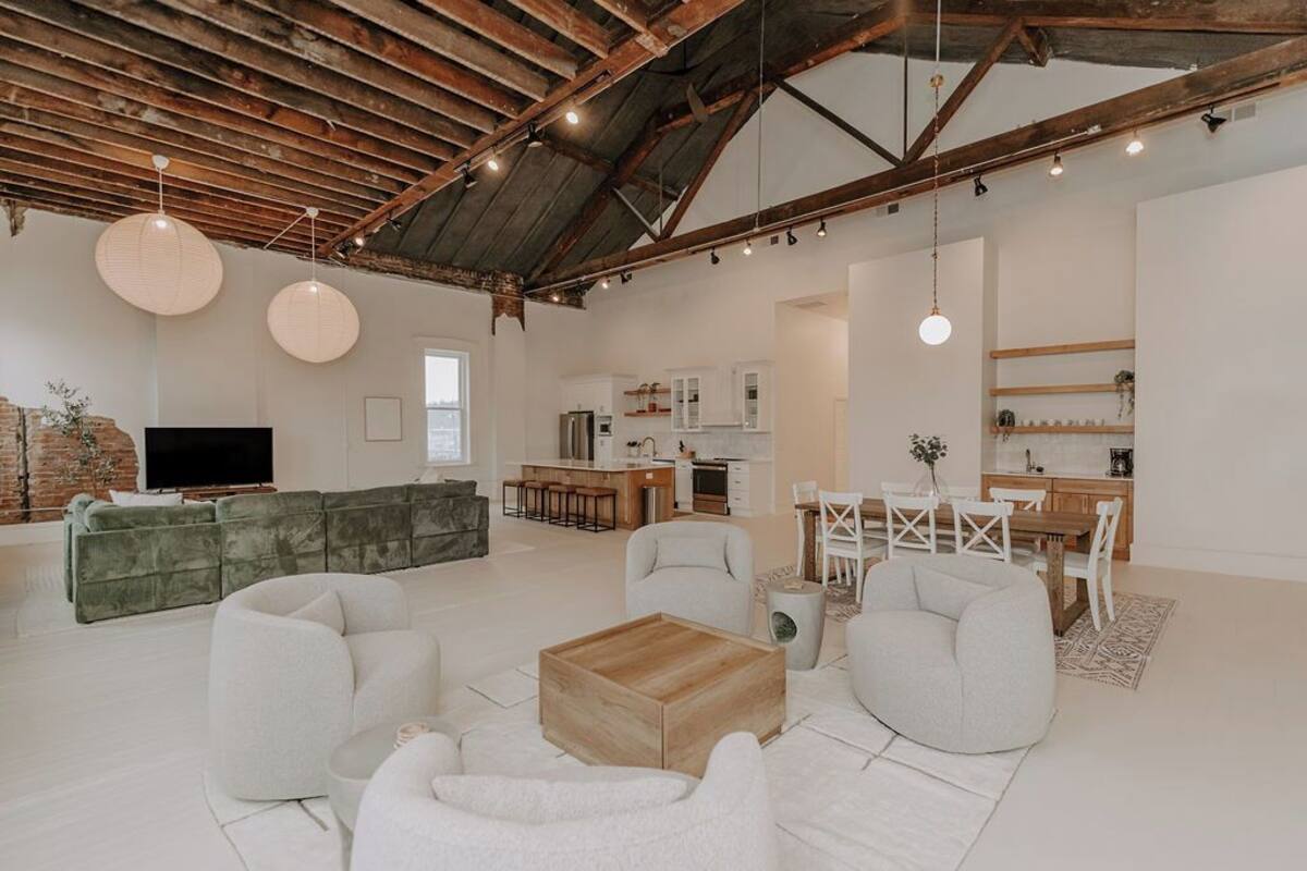 Un amplio espacio de estar con techo alto, una cocina y un comedor.