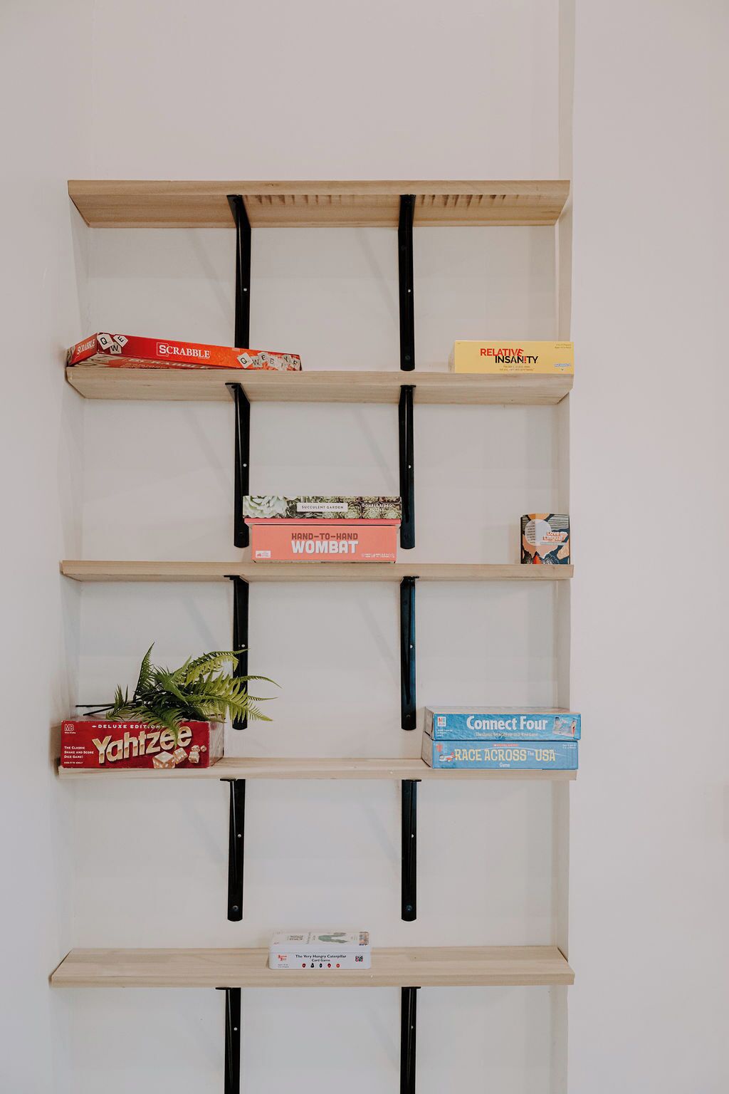 Un estante de pared con varios juegos de mesa.