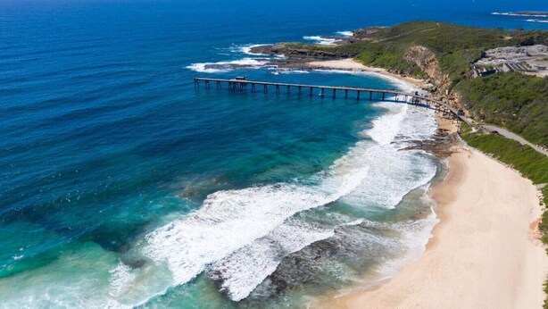 A coastal landscape with a beach, ocean, and a pier extending into the water. - Lakeside Bliss | (10ppl), (5ppl) Spa, Pet-Friendly (Nords Wharf)