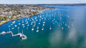 An aerial view of a marina with numerous boats docked, surrounded by a residential area. - Lakeside Bliss | (10ppl), (5ppl) Spa, Pet-Friendly (Nords Wharf)