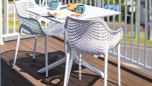 A balcony with a table and chairs, overlooking a body of water with boats. - Lakeside Bliss | (10ppl), (5ppl) Spa, Pet-Friendly (Nords Wharf)