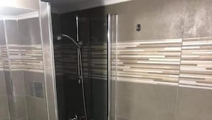 A modern bathroom with a glass-enclosed shower, a sink, and a bidet. - B&B Nonno Walter (Torre del Greco)