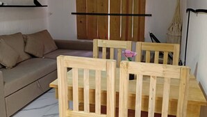 A room with a wooden dining table and chairs, a sofa, and a ceiling fan. - Aldea Tulum 1st floor (Aldea Tulum)