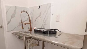 A kitchen with a marble backsplash, a stainless steel countertop, and a gas stove. - Aldea Tulum 1st floor (Aldea Tulum)