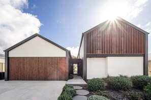 A modern two-story building with a garage and a covered walkway.