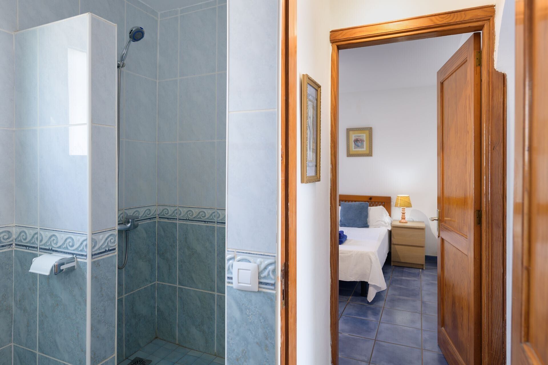 Un baño con ducha, inodoro y dispensador de toallas.