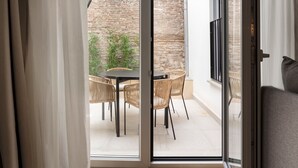 A room with a sliding glass door leading to an outdoor patio with a table and chairs. - Feelathome Palacio de Álamos (Distrito Centro)