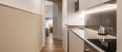 A narrow kitchen with a built-in oven and a stovetop.