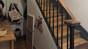 A wooden staircase with black railings and a wooden handrail.