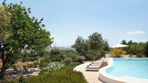 A pool area with lounge chairs and a view of the sea. - Luxury Oceanfront Villa - Catered & Serviced with Private Boat & Skipper (Tavira)