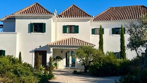 A two-story building with a tiled roof, white walls, and green shutters. - Luxury Oceanfront Villa - Catered & Serviced with Private Boat & Skipper (Tavira)