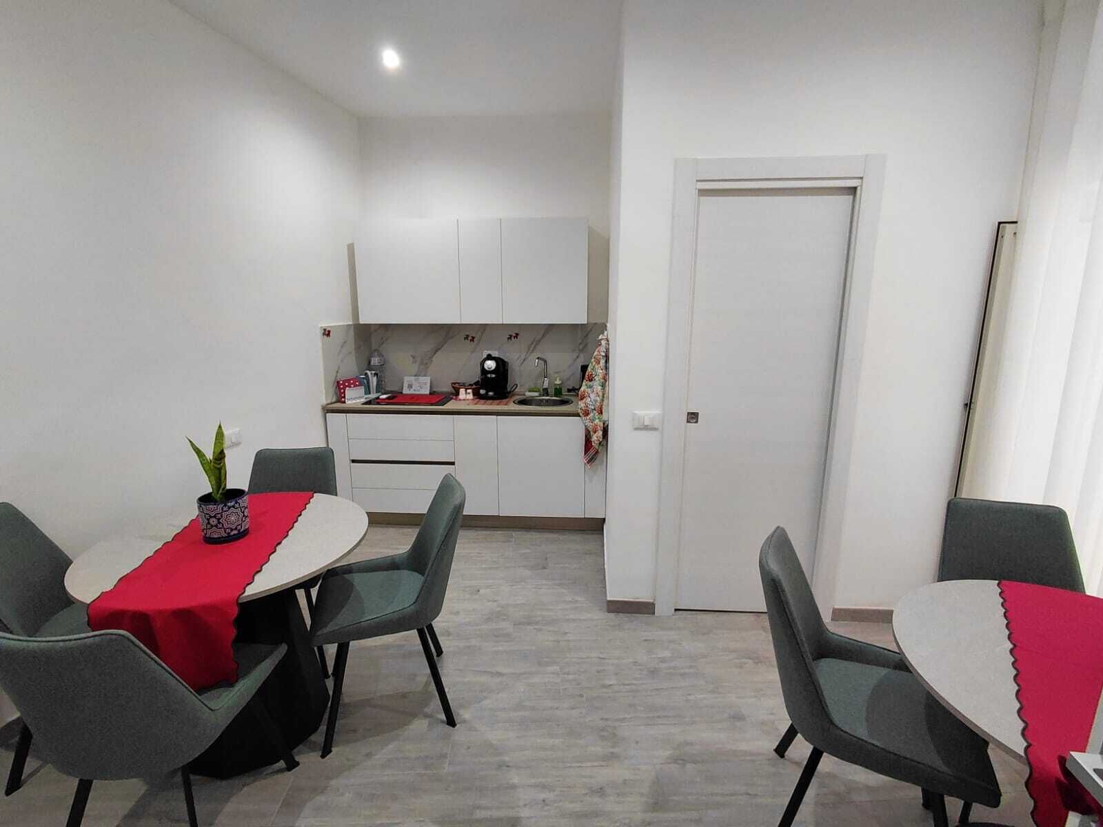 Um espaço compacto com área de refeições, cozinha compacta e porta que dá para outro cômodo.