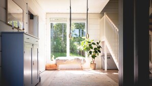 A bright room with a large window, a bed, a plant, and a staircase. - Stay North - Västerskog (Sipoo)