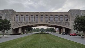 A stone bridge with arched windows, a grassy area, and cars parked on the street. - Private Cozy Studio (Radford)