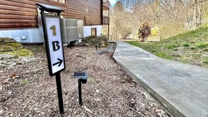 A wooden building with a sign indicating direction. - Private Cozy Studio (Radford)