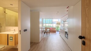 Eine moderne Küche mit Essbereich, einer Duschkabine aus Glas und Blick ins Freie.