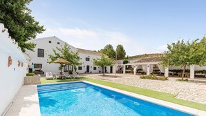 A swimming pool, white building, and outdoor seating area. - Holiday Home 'Cortijo Caracate' with Mountain View, Wi-Fi and Air Conditioning (Archidona)