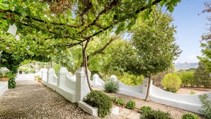 A pathway leading through a garden with white walls and various plants. - Holiday Home 'Cortijo Caracate' with Mountain View, Wi-Fi and Air Conditioning (Archidona)