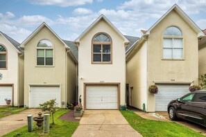 A row of residential houses with garage doors, numbered 7220 and 7218, and a parked car.