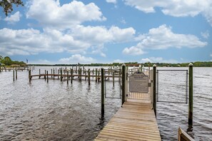A wooden dock leading to a gated dock area with a sign indicating 'Hidden Bay Village.'