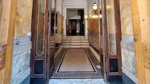 A grand hallway with marble flooring and wooden doors. - HEBE Eternity Rooms (Rome)