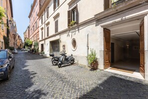 Una calle adoquinada con una moto estacionada y un automóvil.