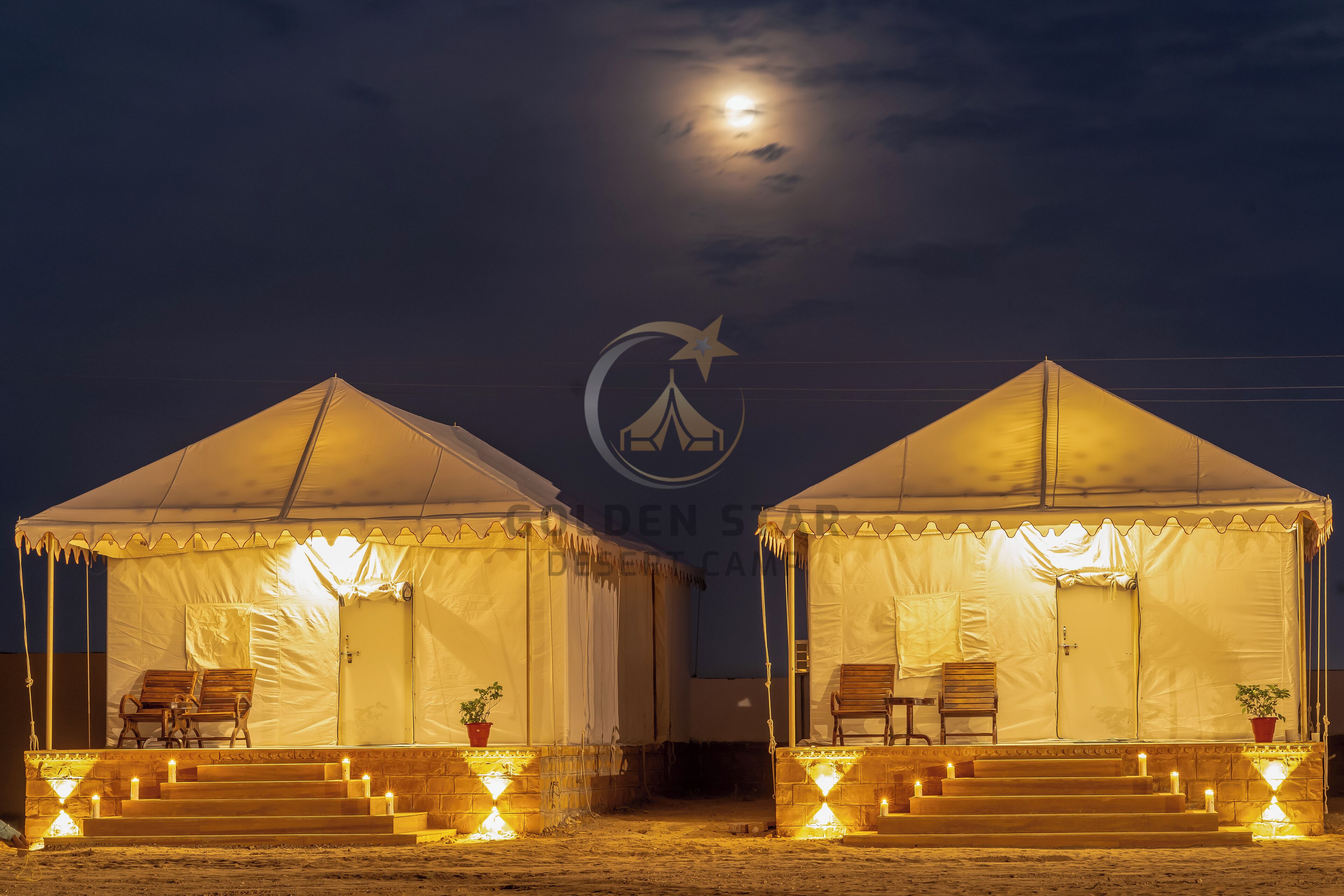 Two tents with steps leading up to the entrance, each with a chair and a potted plant.