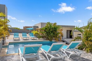A poolside area with lounge chairs and a swimming pool. - Casa Paz y Calidez, Papaya Hill Resort, Grote Berg (Grote Berg)