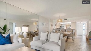 Un salon moderne comprenant un canapé, une table basse et un coin repas avec une table et des chaises.