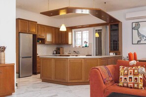 A modern kitchen with wooden cabinets, a stainless steel refrigerator, and a central island. - Spacious 3 Bd House in Alimos Athens Riviera (Alimos)