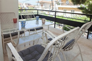 Un balcone con tavolo, sedie e due tazze.