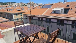 A rooftop terrace with a windmill, a table, and two chairs. - The Attic Room on Niella Street, in the city center and near the sea (Savona)