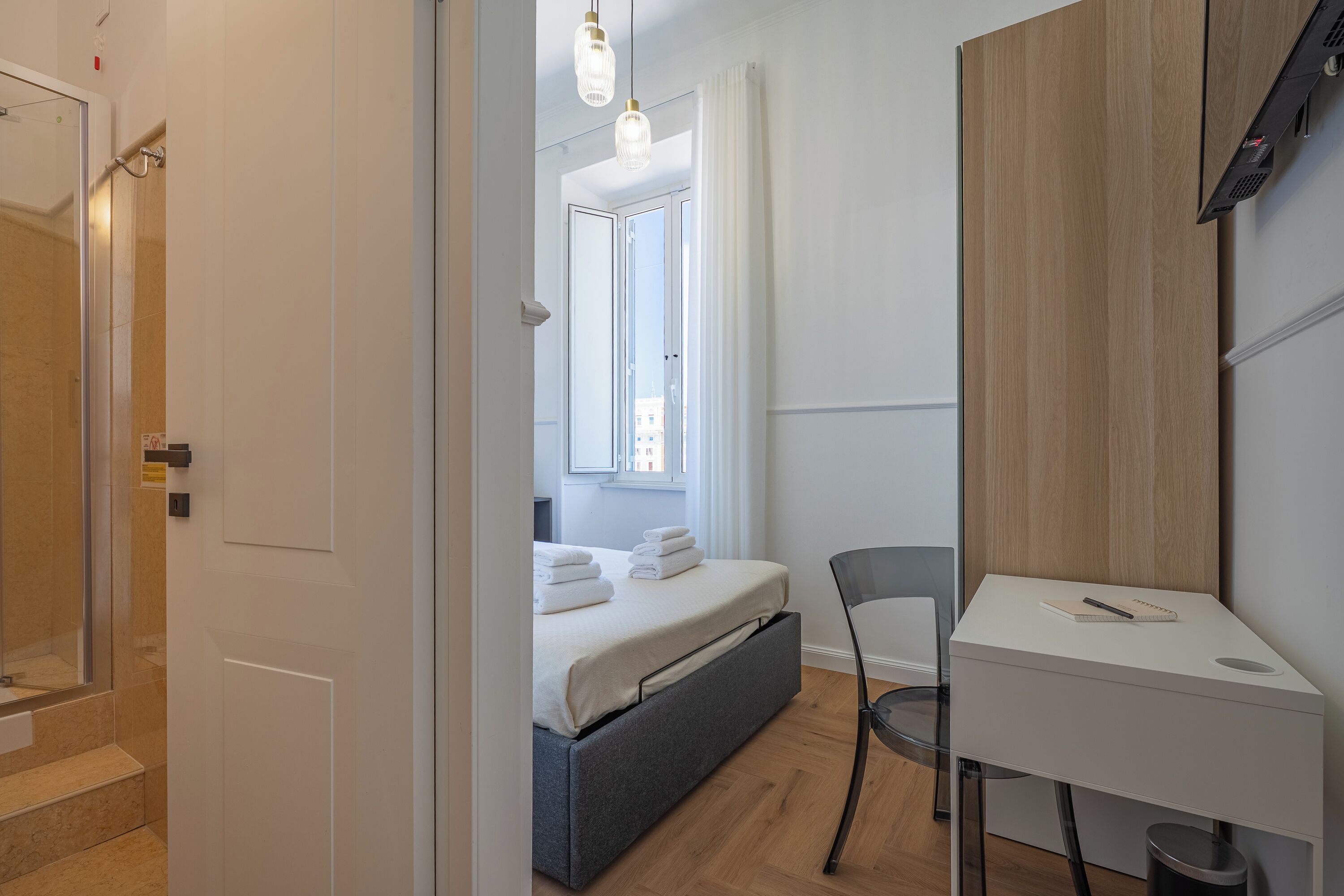 A modern bedroom with a bed, a desk, and a chair.