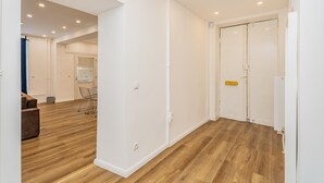 Un intérieur moderne avec un plancher en bois, des murs blancs et une porte fermée.