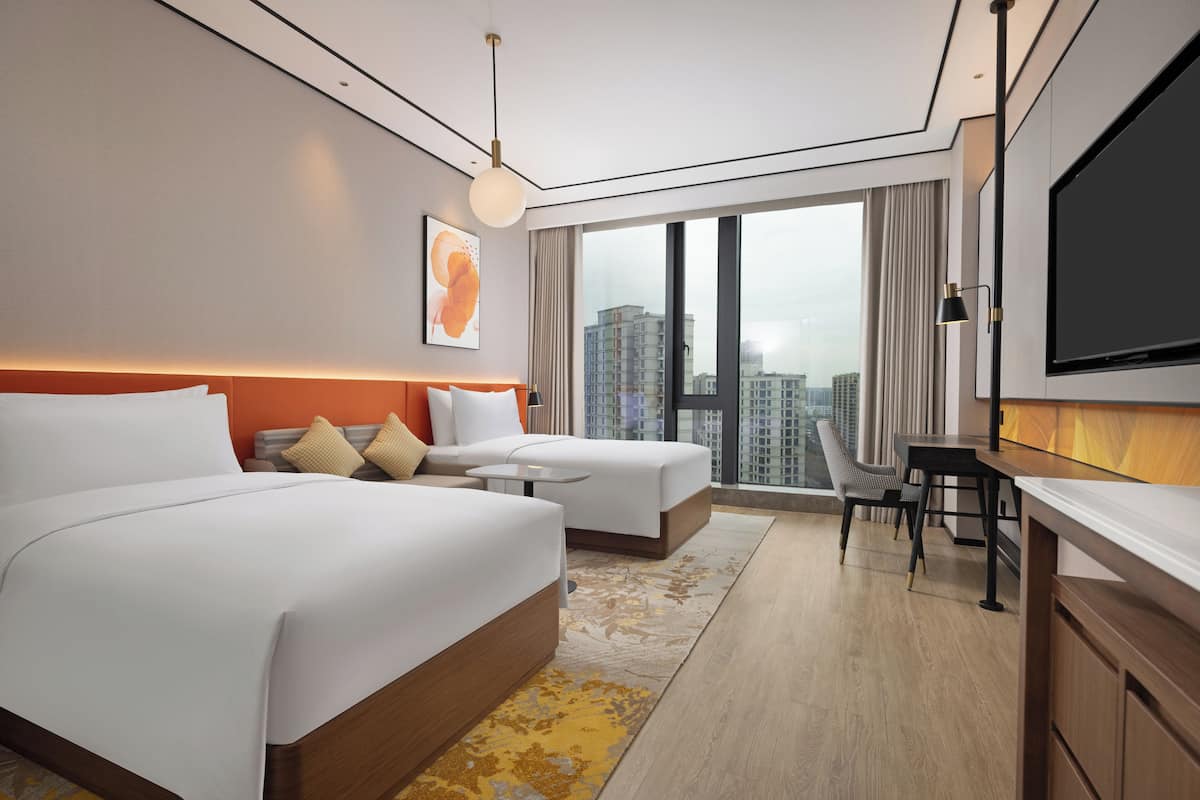 Ein modernes Hotelzimmer mit einem großen Bett, einem Schreibtisch und einem Fernseher.