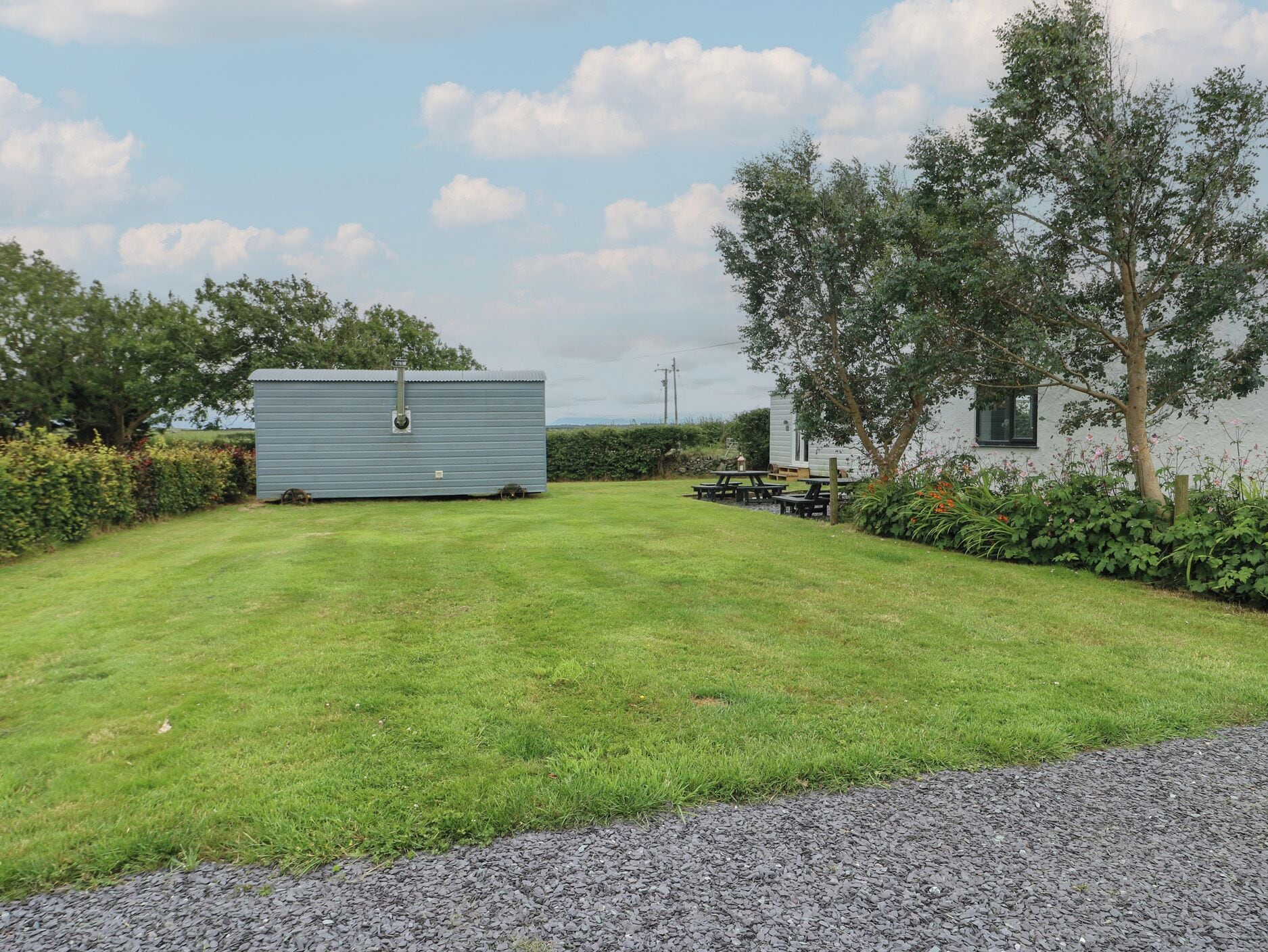 A grassy area with a small shed and a picnic table.