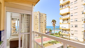 A balcony with a sliding glass door, a view of a tennis court, and adjacent high-rise buildings. - Apartment 'Playa Algarrobo Costa' with Sea Views, Wi-Fi and Air Conditioning (Algarrobo-Costa)