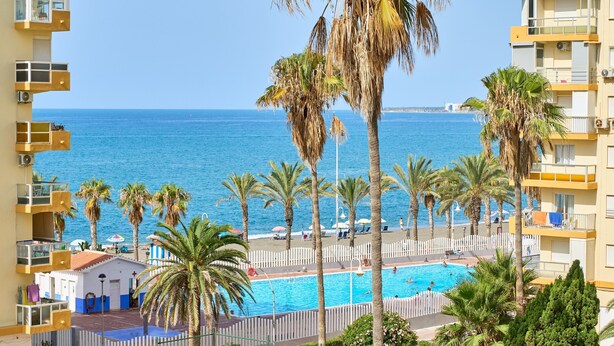 A hotel with a pool, palm trees, and a view of the sea. - Apartment 'Playa Algarrobo Costa' with Sea Views, Wi-Fi and Air Conditioning (Algarrobo-Costa)