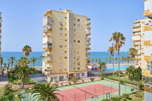 A multi-story building with balconies, a tennis court, and a pool. - Apartment 'Playa Algarrobo Costa' with Sea Views, Wi-Fi and Air Conditioning (Algarrobo-Costa)