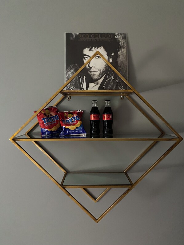 A diamond-shaped shelf with a framed picture and snacks.