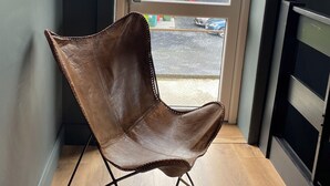 A leather chair in a room with a door leading outside. - The Snug at the BH (Garrisker)