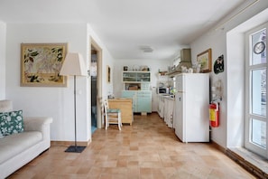 A kitchen with a dining area, a sofa, a lamp, and a fire extinguisher.