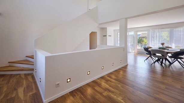 A modern interior with a staircase, wooden flooring, and a dining area with chairs and a table. - Moselquartier "Winzer-Residenz" up to 8 persons | 2 balconies | box-spring beds (Piesport)