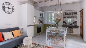 Una cocina moderna con comedor, un sofá y un reloj en la pared.