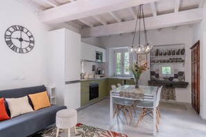 Une cuisine moderne avec un coin repas, un canapé et une horloge au mur.